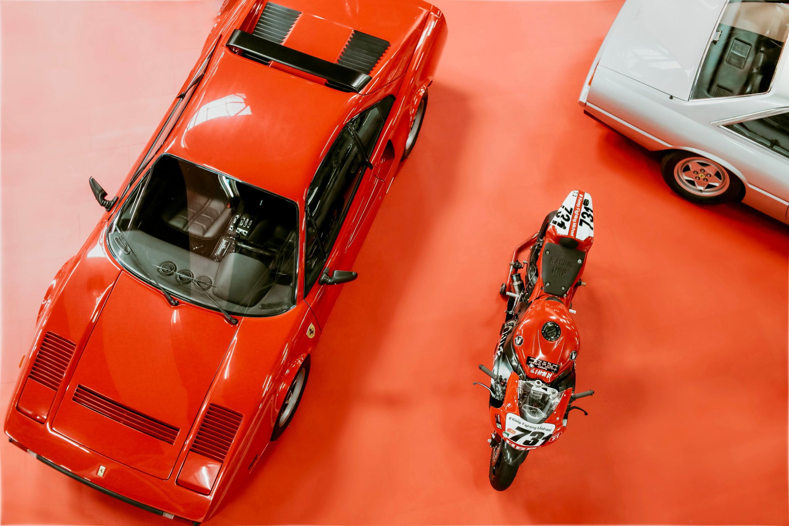 Ferrari classique et moto exposées salon automobile
