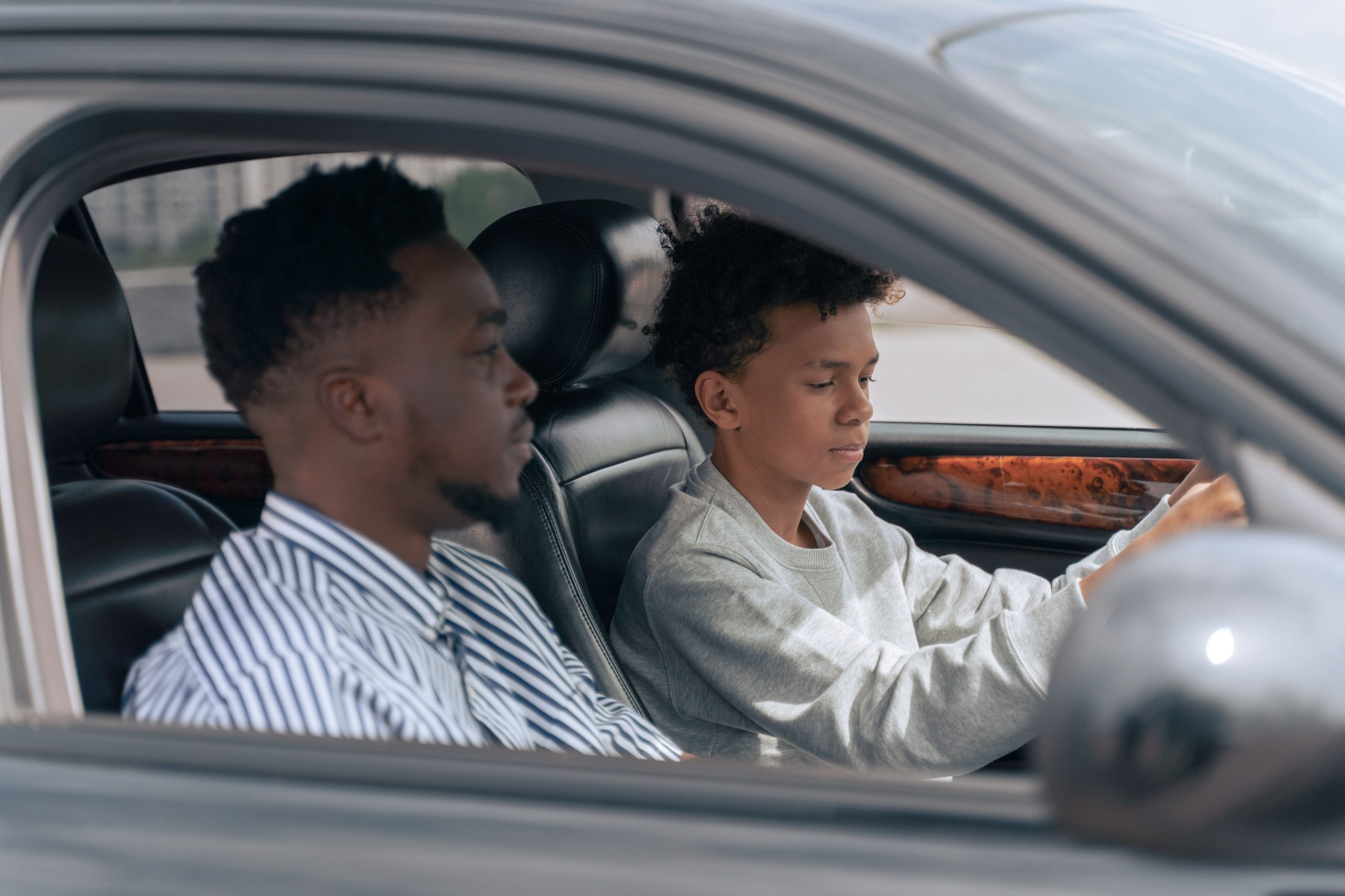 Père accompagnant son fils en conduite apprentissage