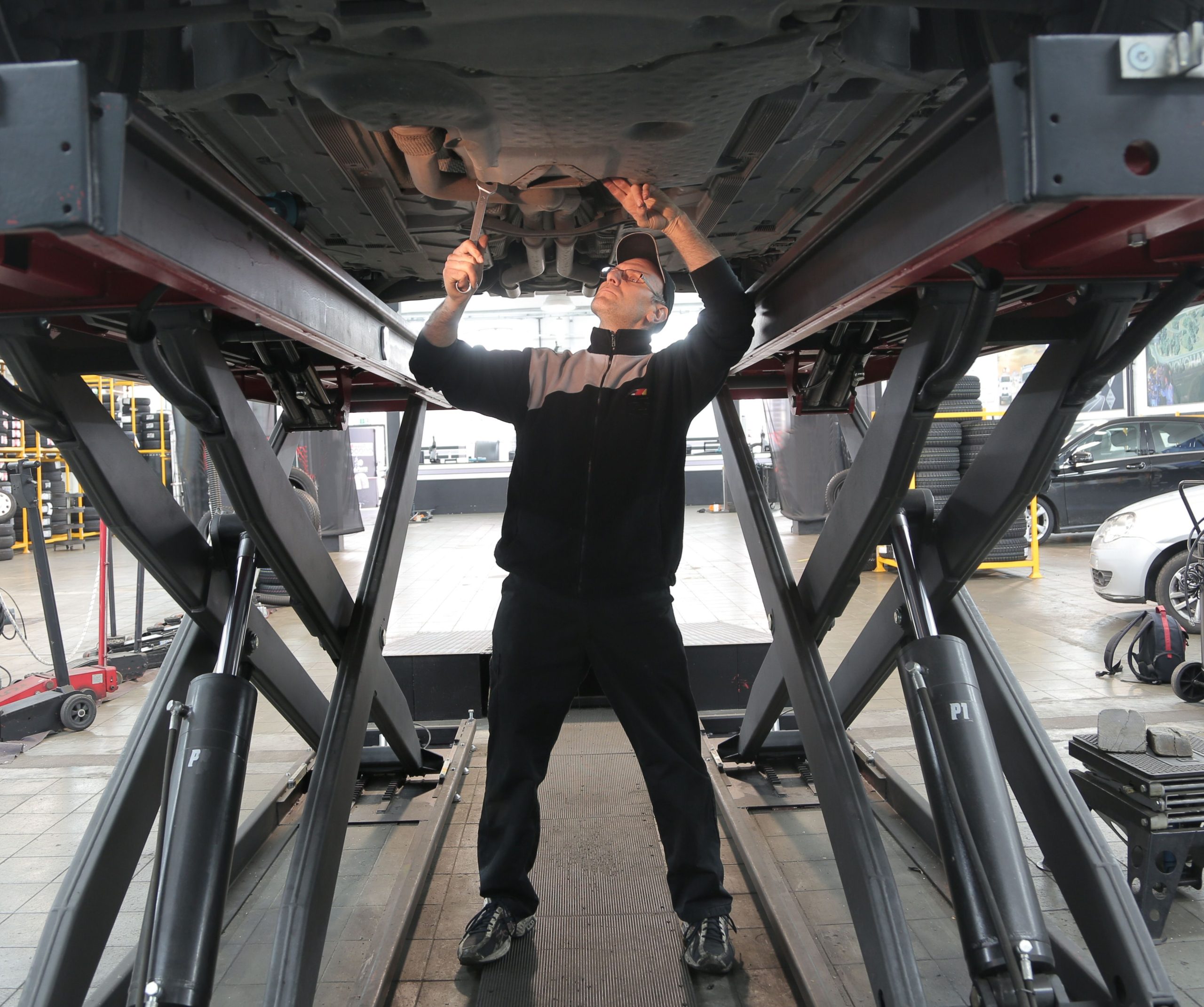 Mécanicien réparant véhicule garage professionnel