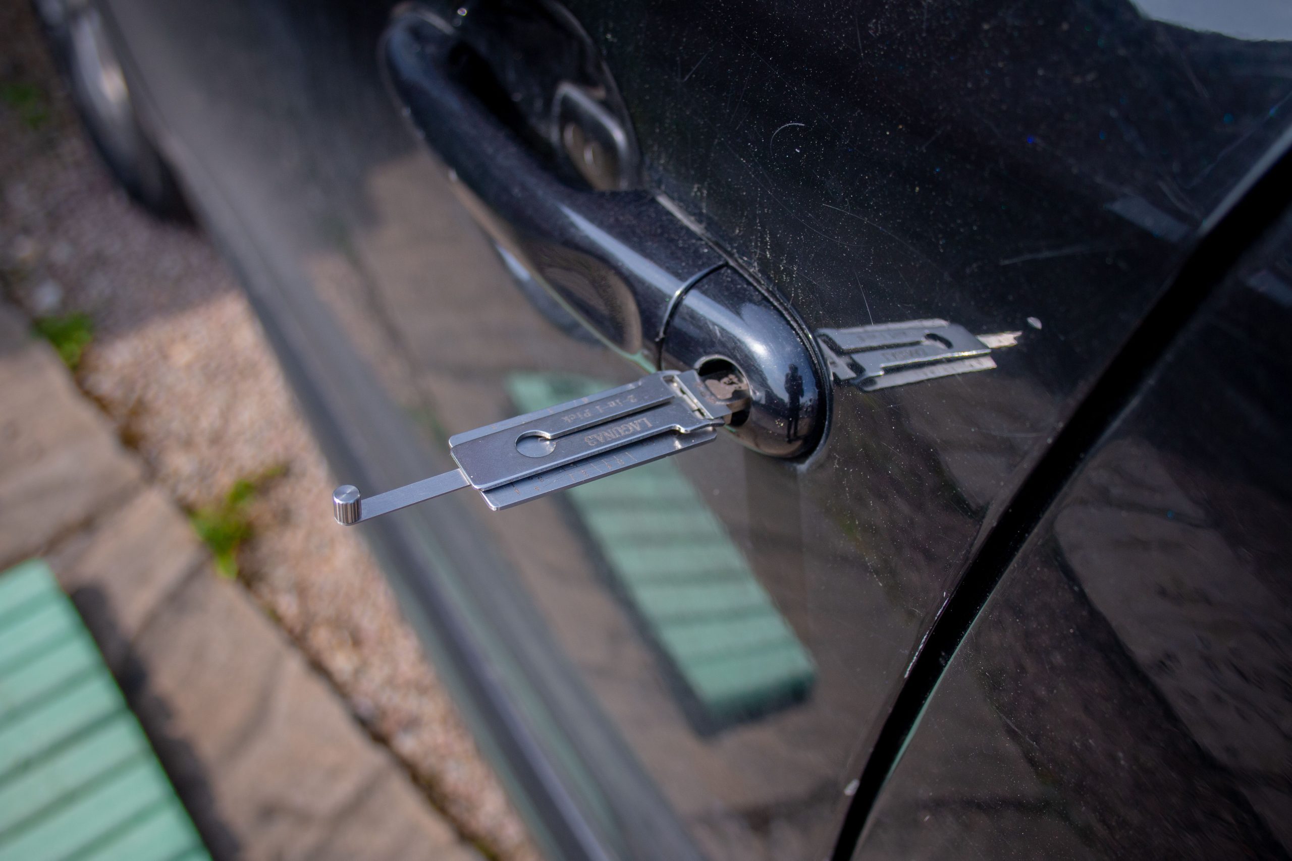 Outil serrurier dans serrure porte automobile