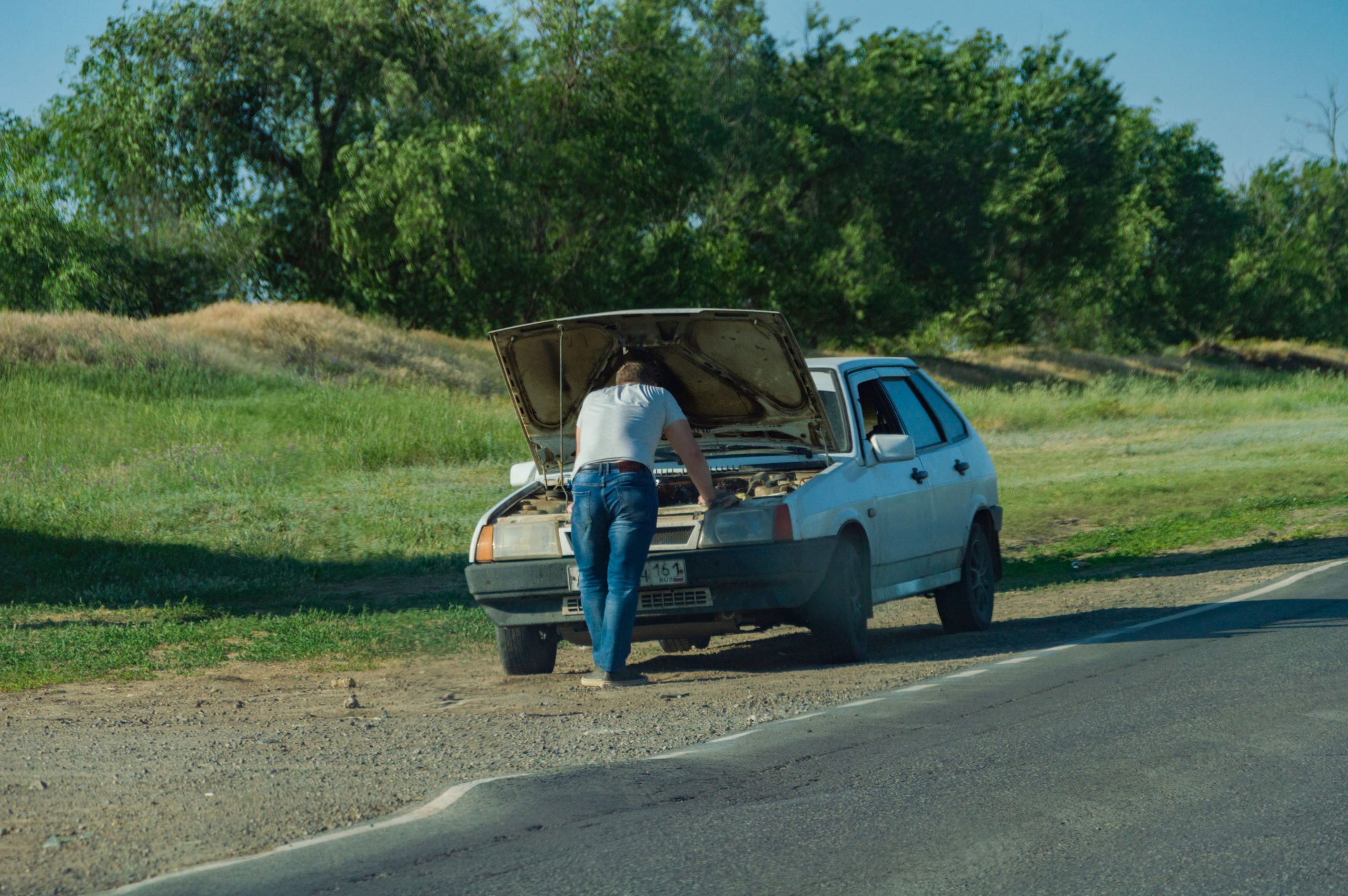 Homme inspectant panne automobile sur route