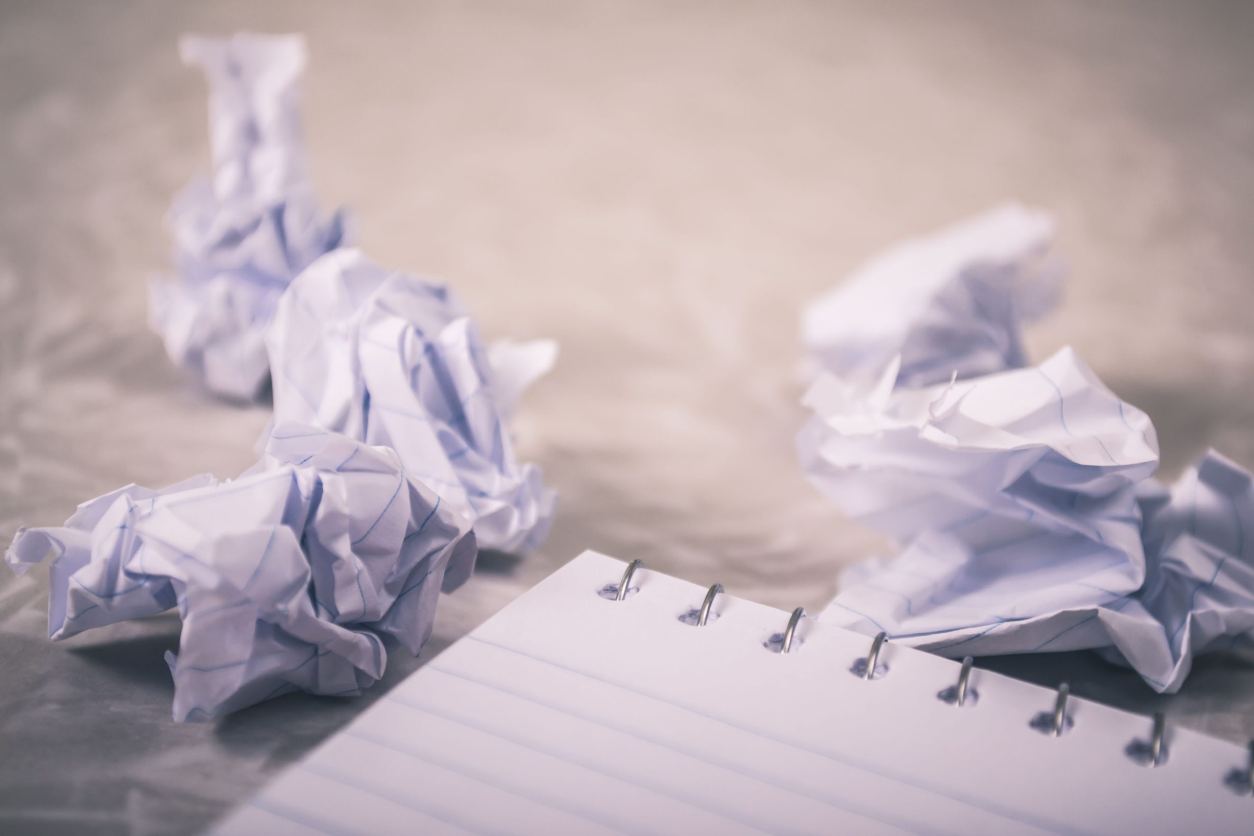 Papiers froissés autour d'un bloc-notes