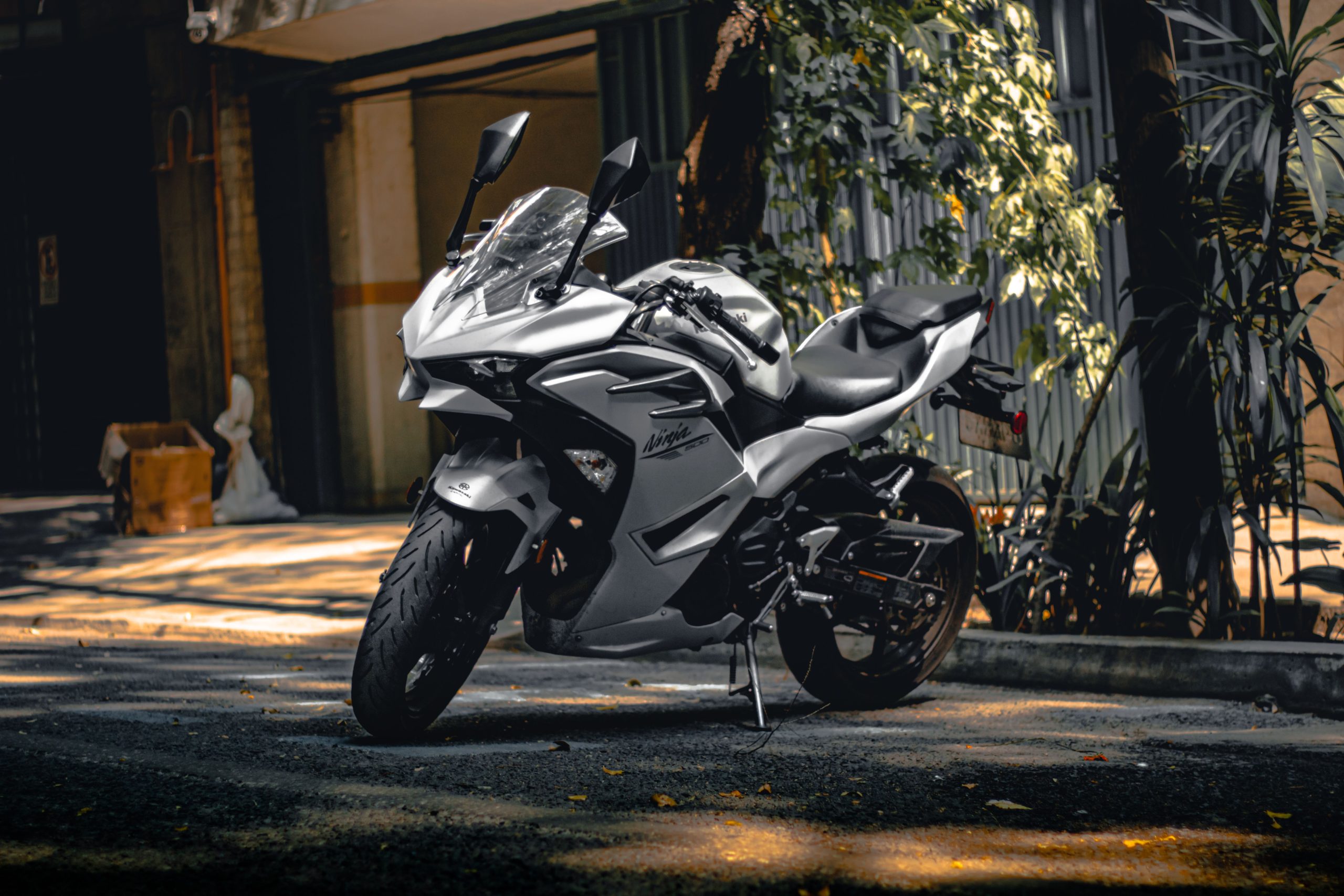 Moto blanche garée dans une rue ombragée