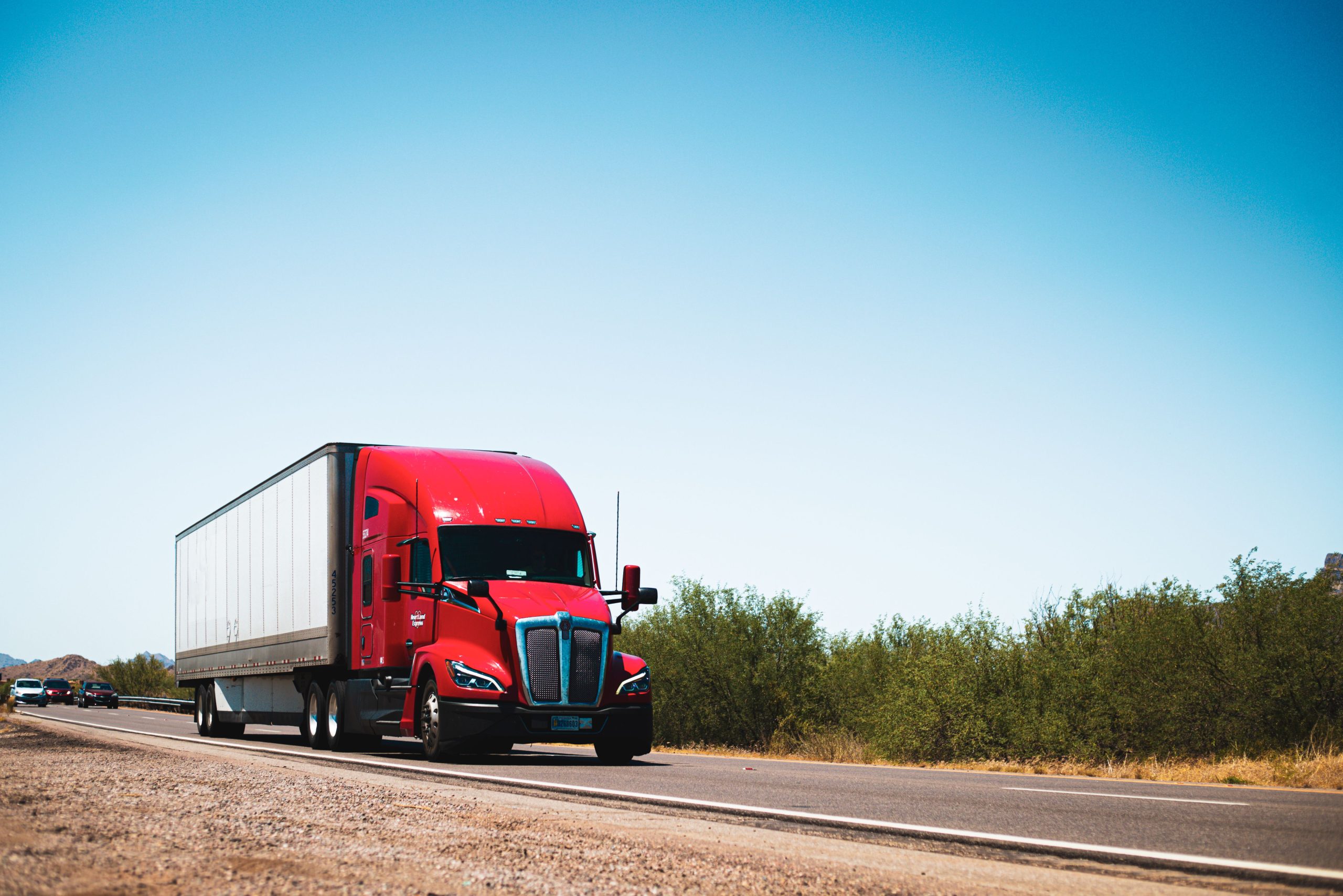 Semi-remorque rouge sur autoroute ensoleillée